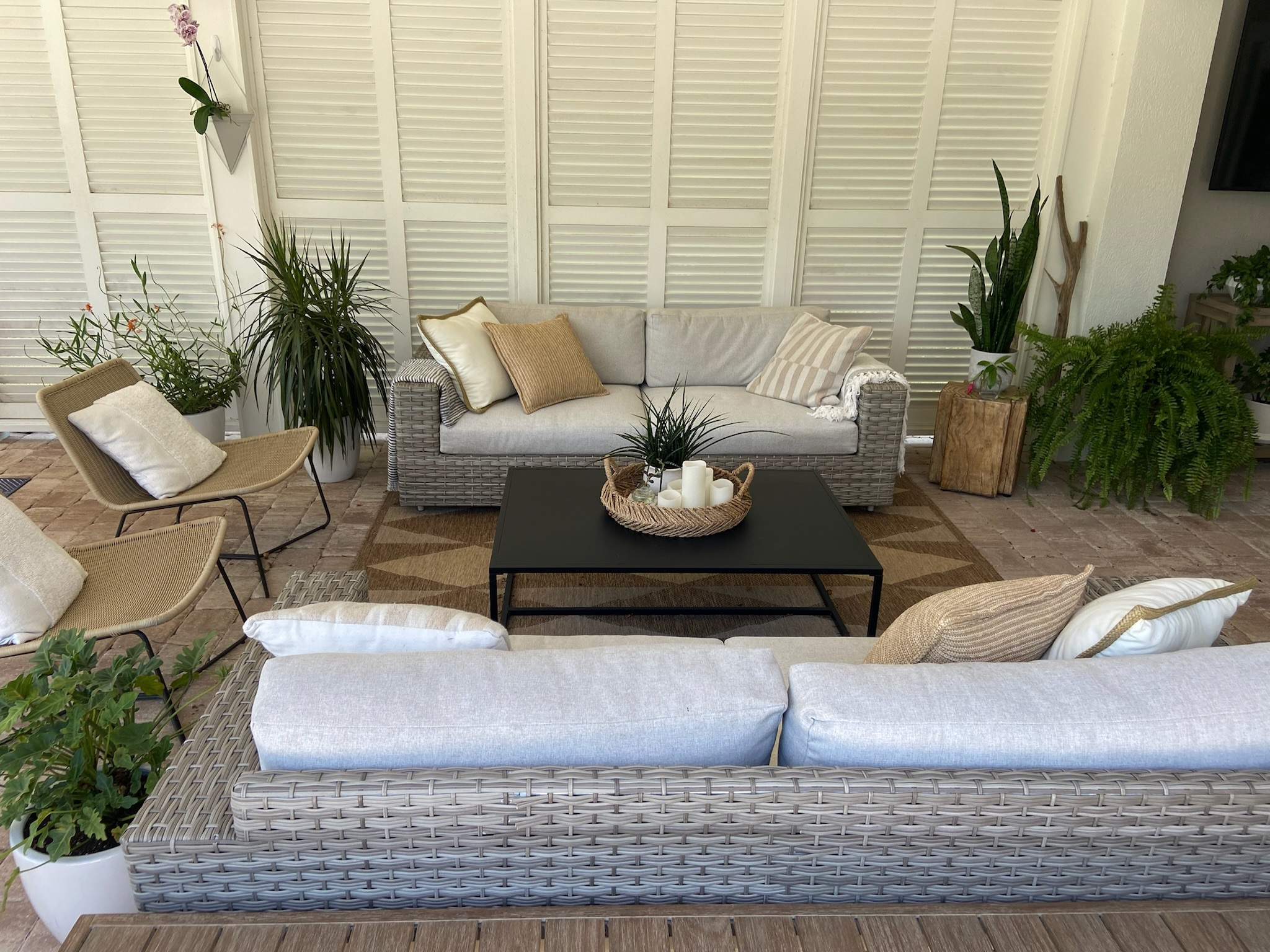 This patio seating area is comprised of two love seats and chairs with a coffee table in the middle. All the furniture gives off a coastal modern vibe.