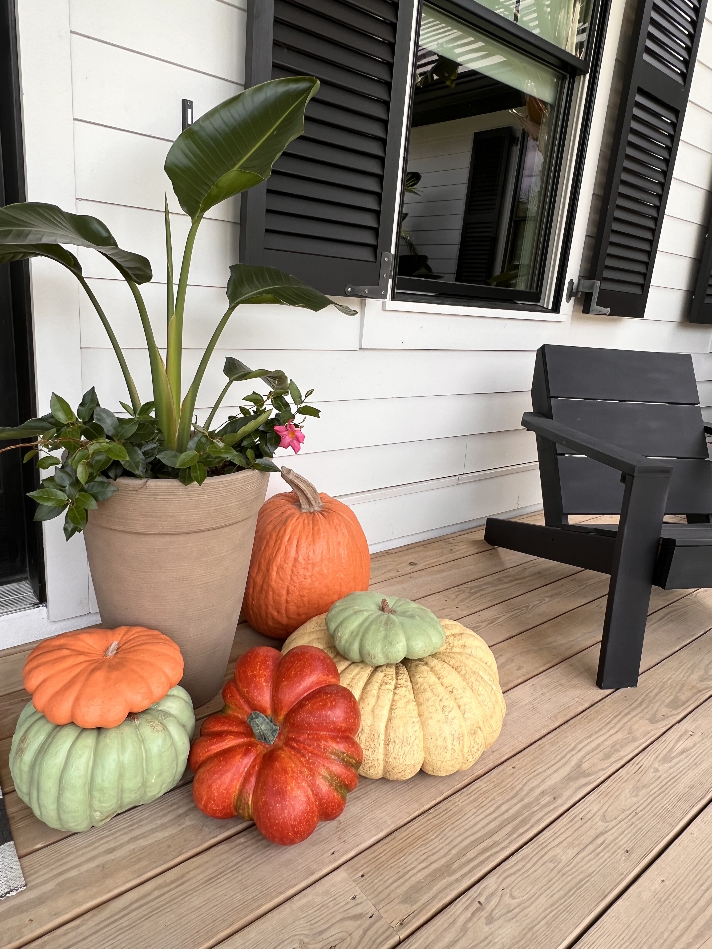 An asymmetrical stack of faux pumpkins gives your front porch a warm Fall welcome. 
