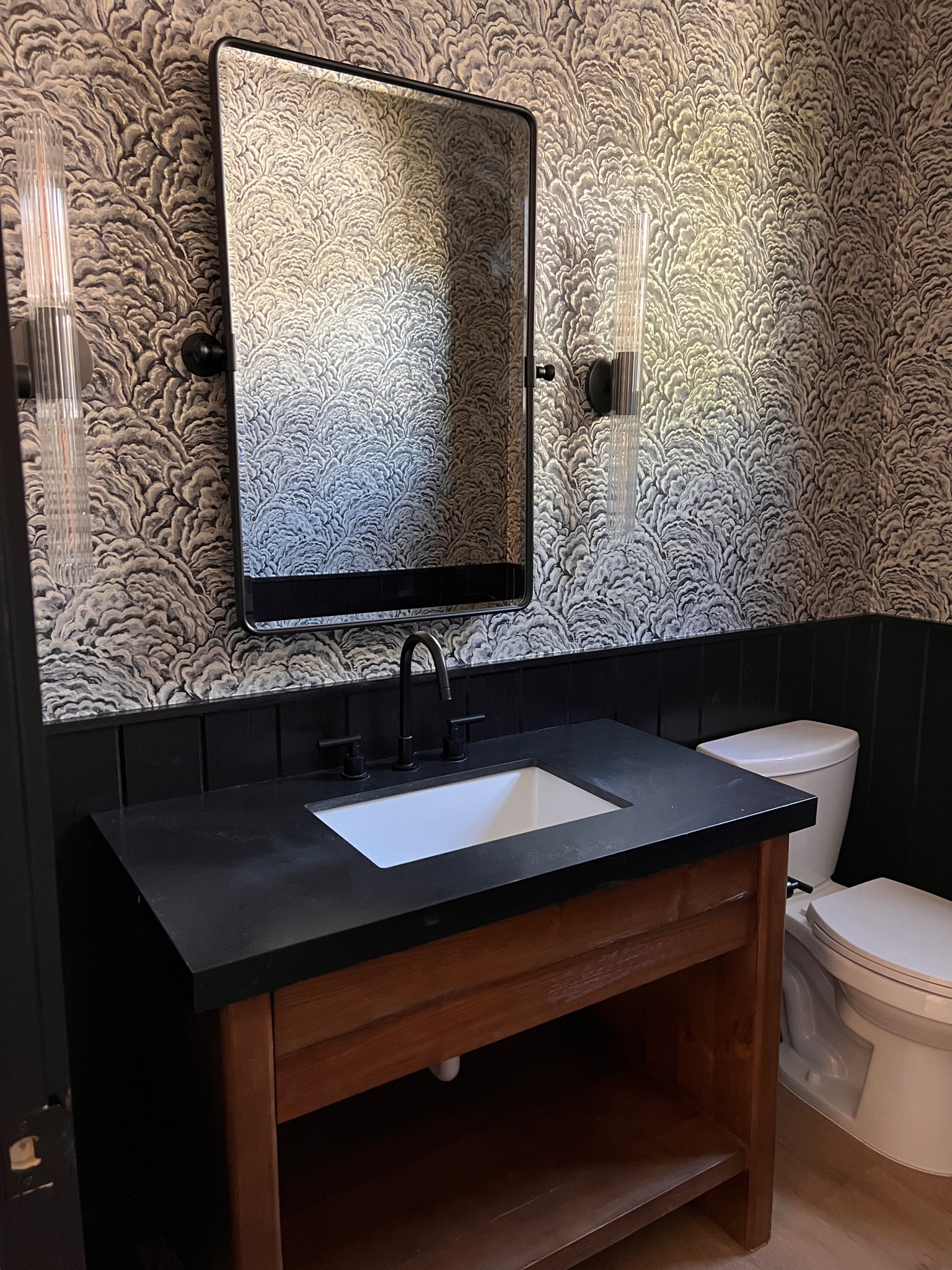 This bathroom uses a dark patterned wallpaper to give a sophisticated touch.