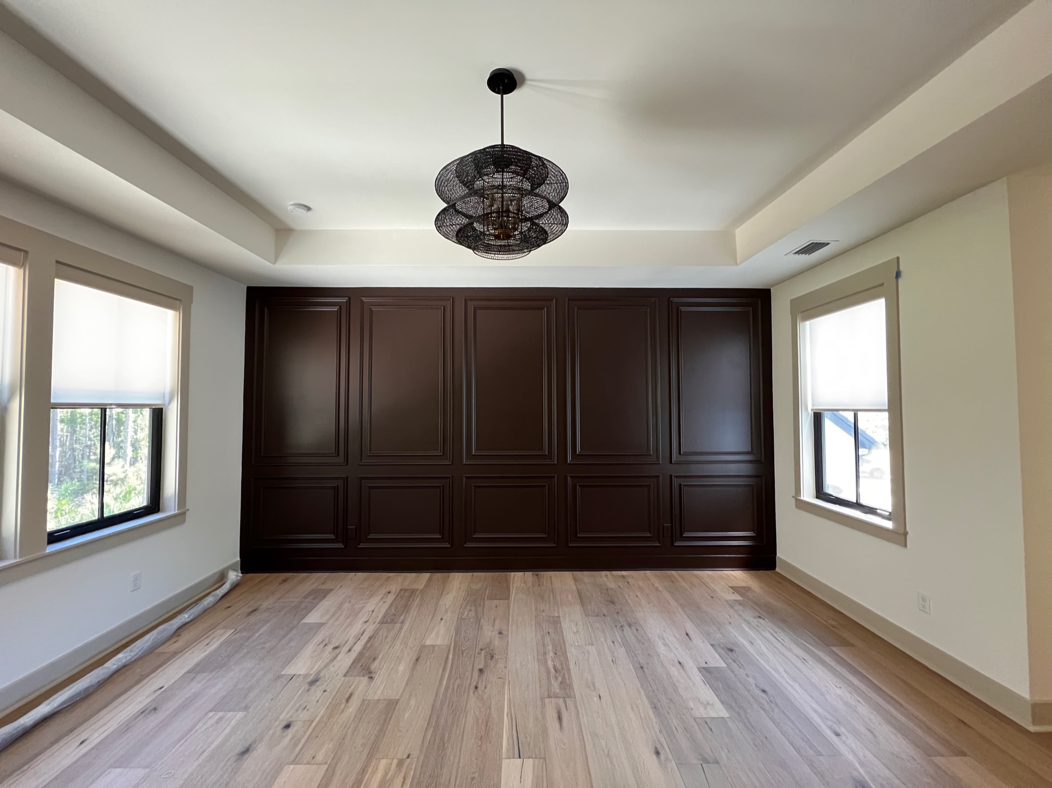 This dark brown dining room accent wall was designed by Welcome Home Styling.