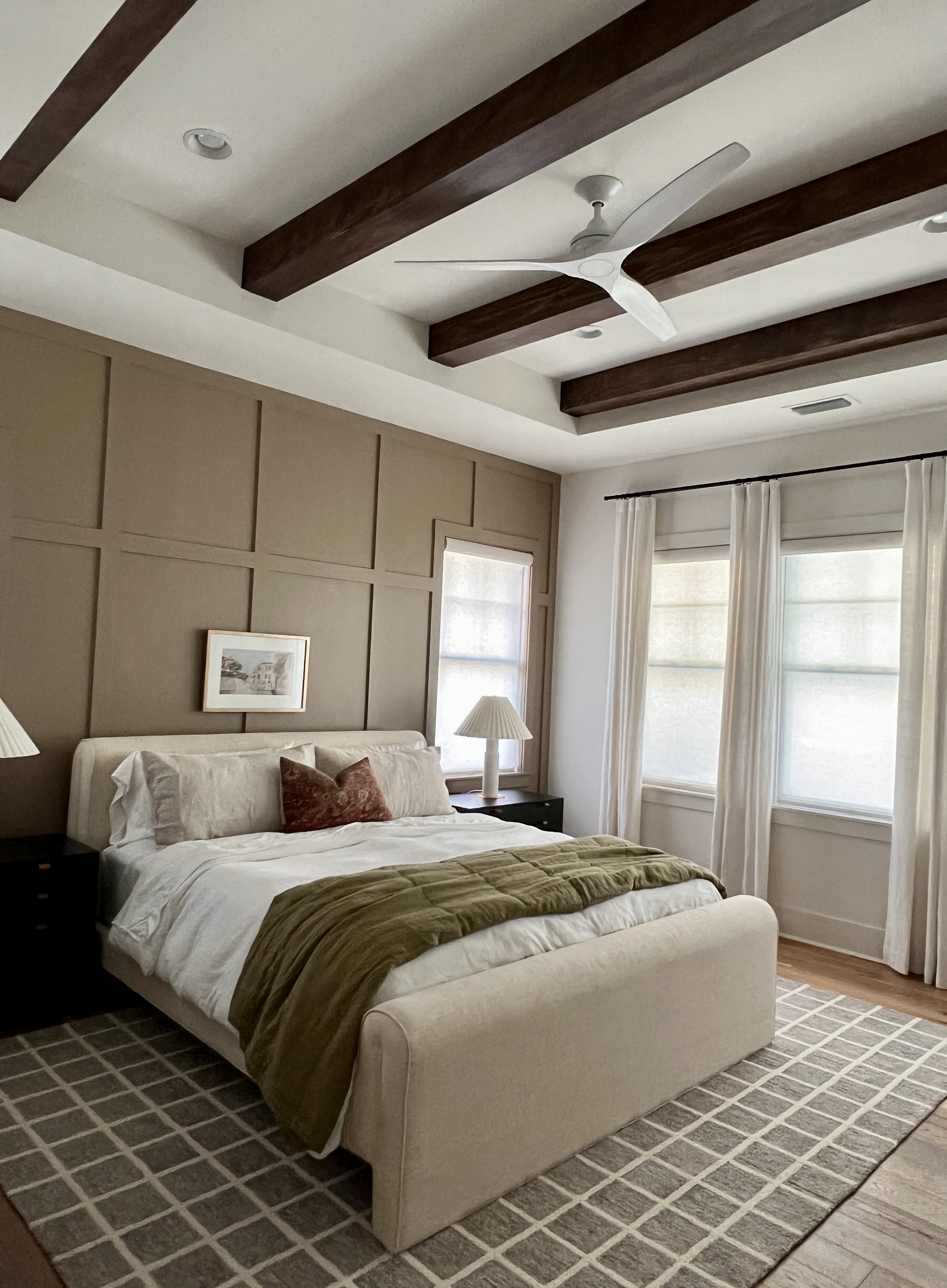 The gorgeous bedroom features a classic board and batten accent wall along with a ceiling treatment. 