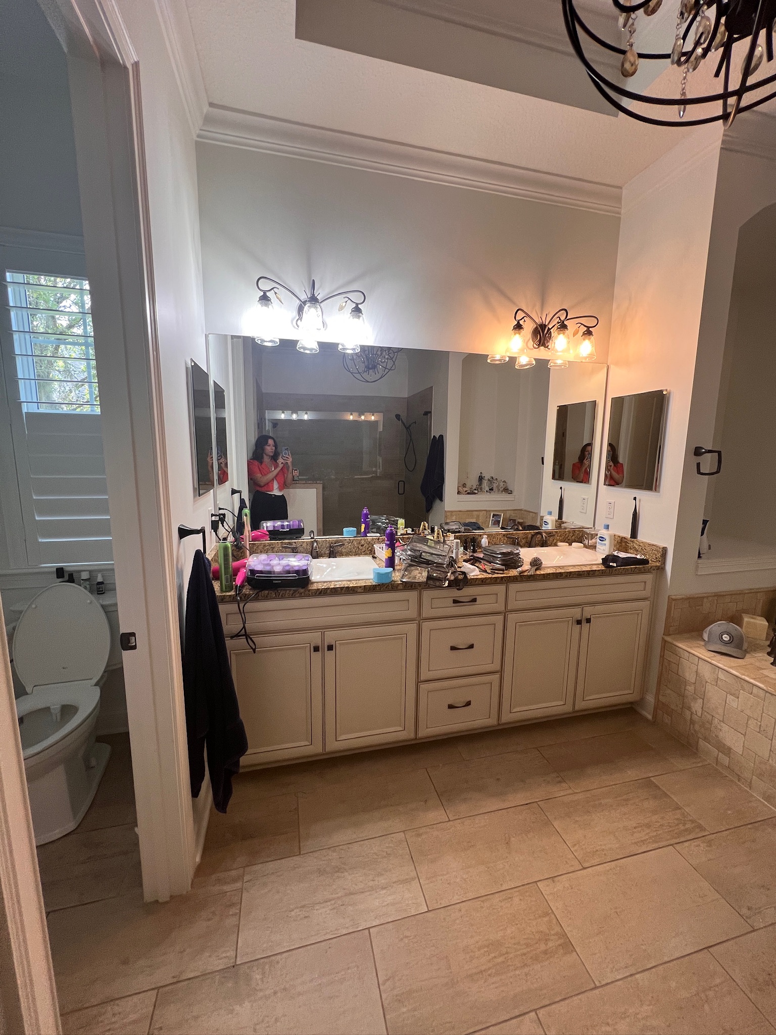 Jessica Woodward is gathering pictures in this client's bathroom during their consultation for interior design services.