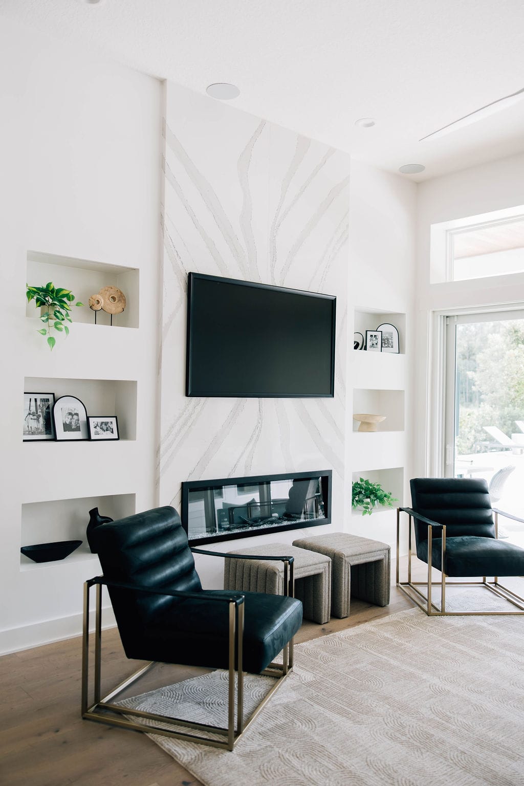 A stylish living room with pristine white walls and modern black chairs, reflecting a clean and contemporary aesthetic. Designed by Welcome Home Styling an interior design firm Jacksonville.<br />
