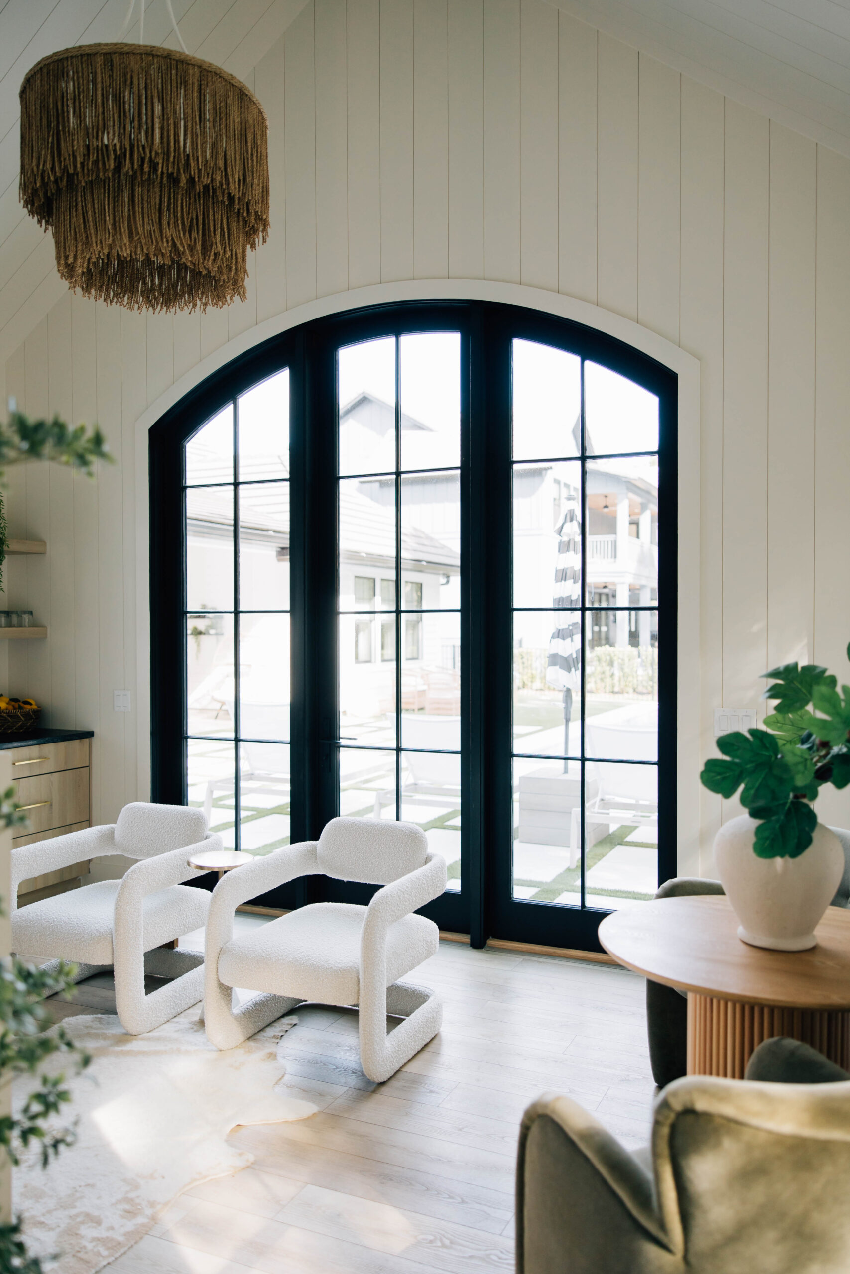 A contemporary living room showcasing white walls paired with elegant black windows, enhancing the room's aesthetic appeal.