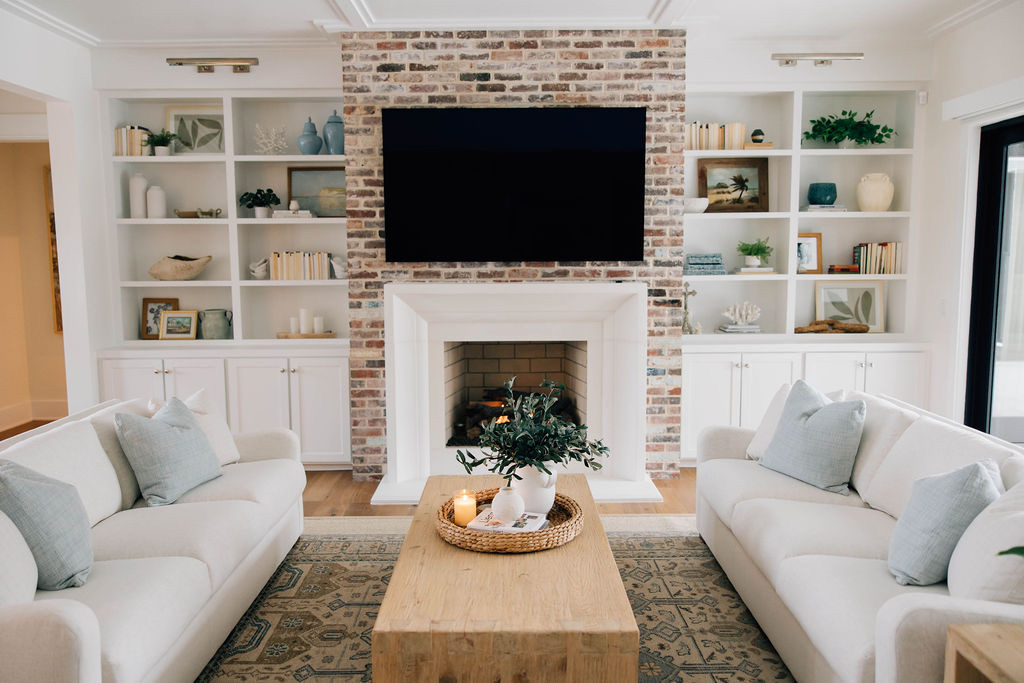 Coastal casual living room with a brick accent wall, plush furniture, and bright accents.