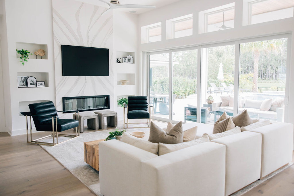 living room design by Welcome Home Styling with plush and modern furnishings and a custom fireplace area.