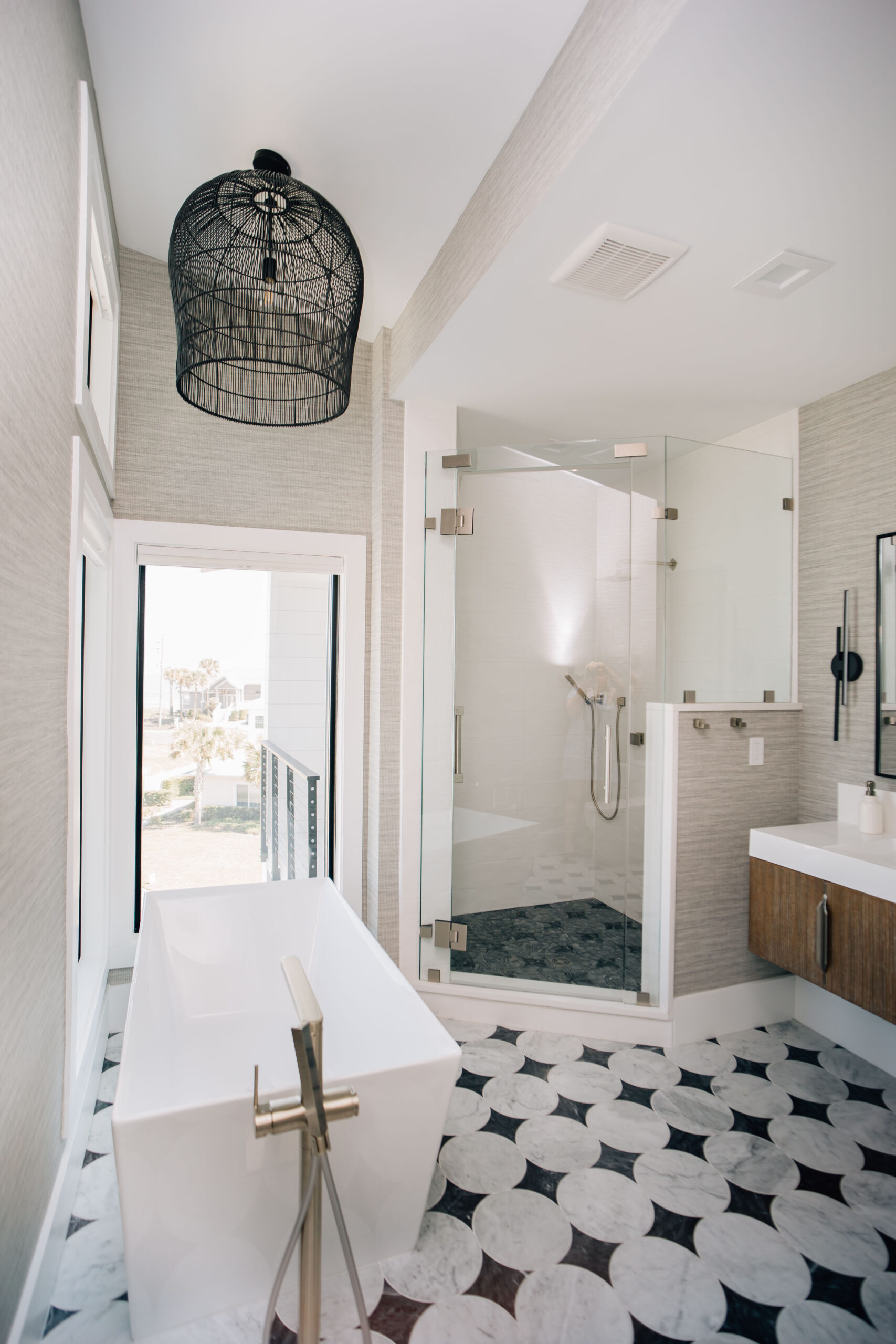 bathroom with freestanding bathtub, walk-in shower, and bold tile flooring.