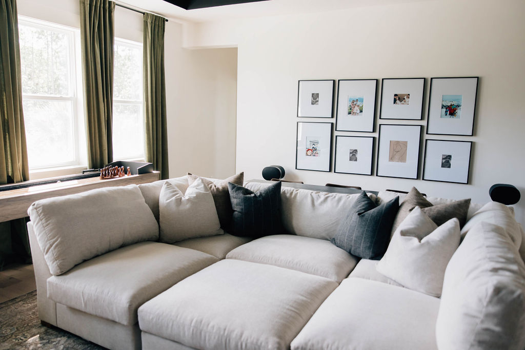 Bright and inviting family room styled with a plush sectional, custom photo gallery wall, and layered texture, showcasing functional interior design for a family