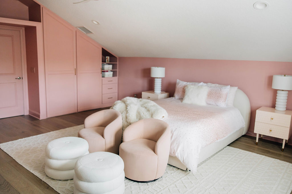 Soft pink room with custom built-ins, cozy chairs, and plush bedding, an elevated approach to kids' room decor by an interior designer focused on family living.