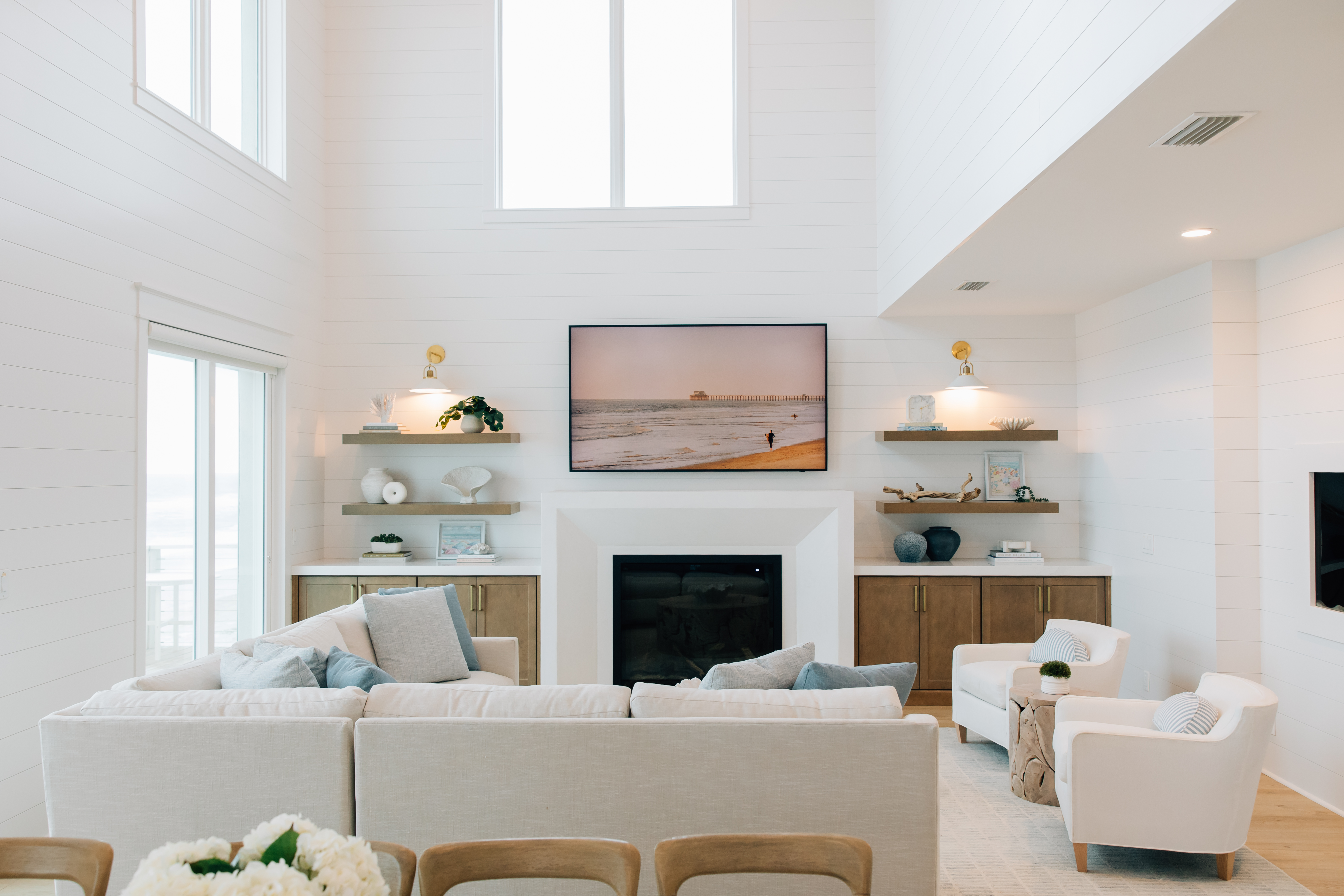 Elegant living room with built-in shelving, light wood cabinetry, and layered textures designed by a Jacksonville interior designer.