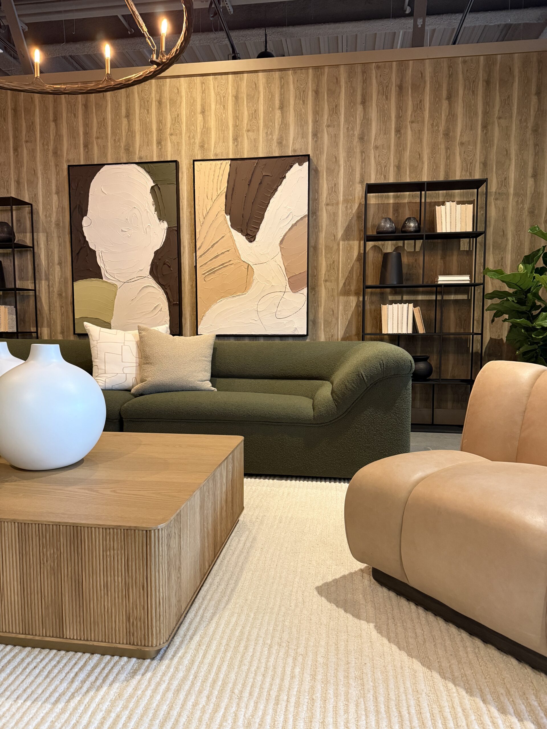 Neutral living area with an olive green sofa and modern artwork.