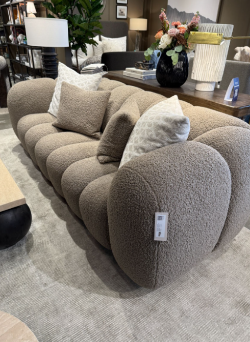 Modern gray sofa featuring a bold shape, rounded edges, and soft fabric.