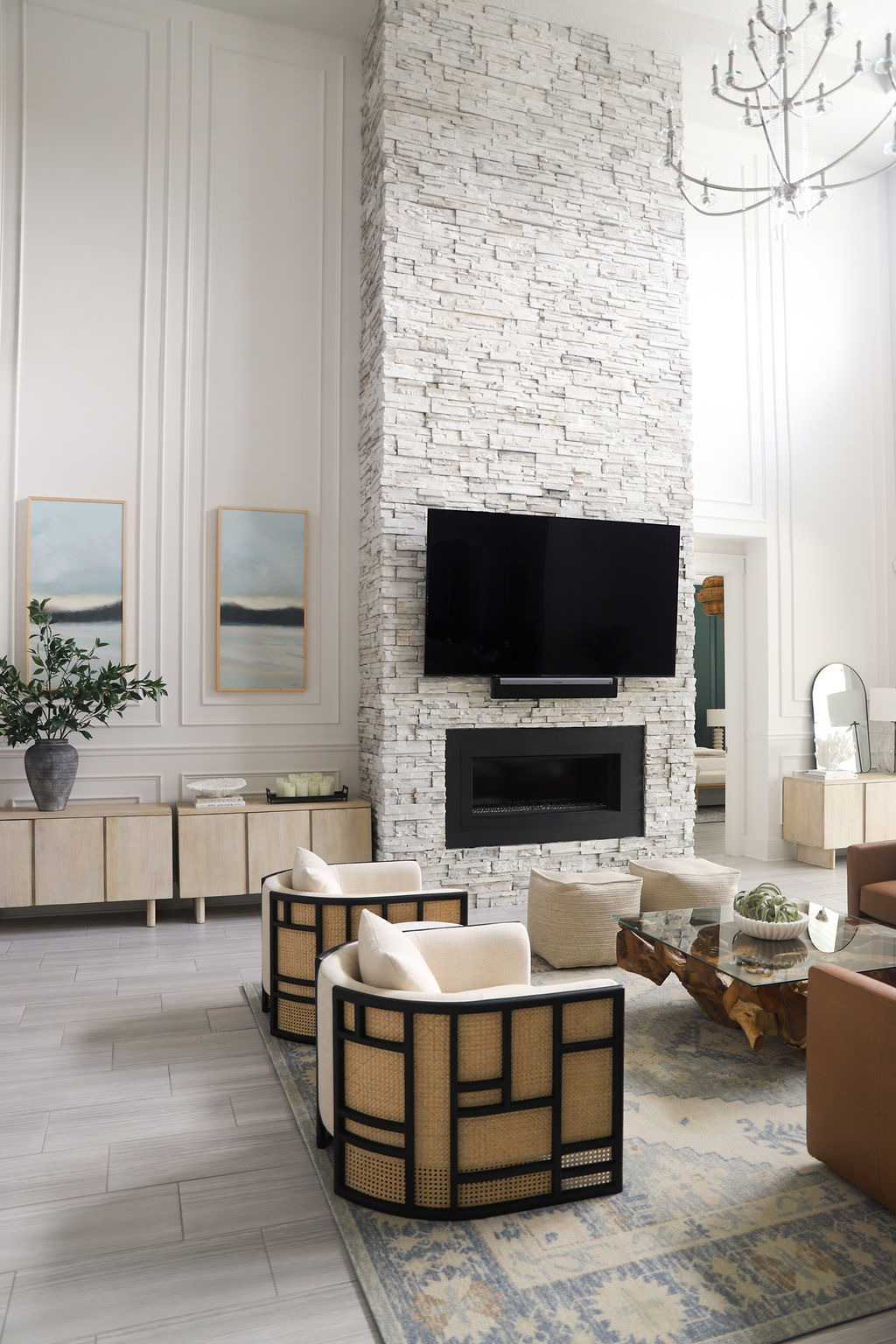 Living room in a Ponte Vedra Beach home with a custom stone fireplace feature wall, millwork on the wall, and modern seating designed by a Ponte Vedra interior designer.