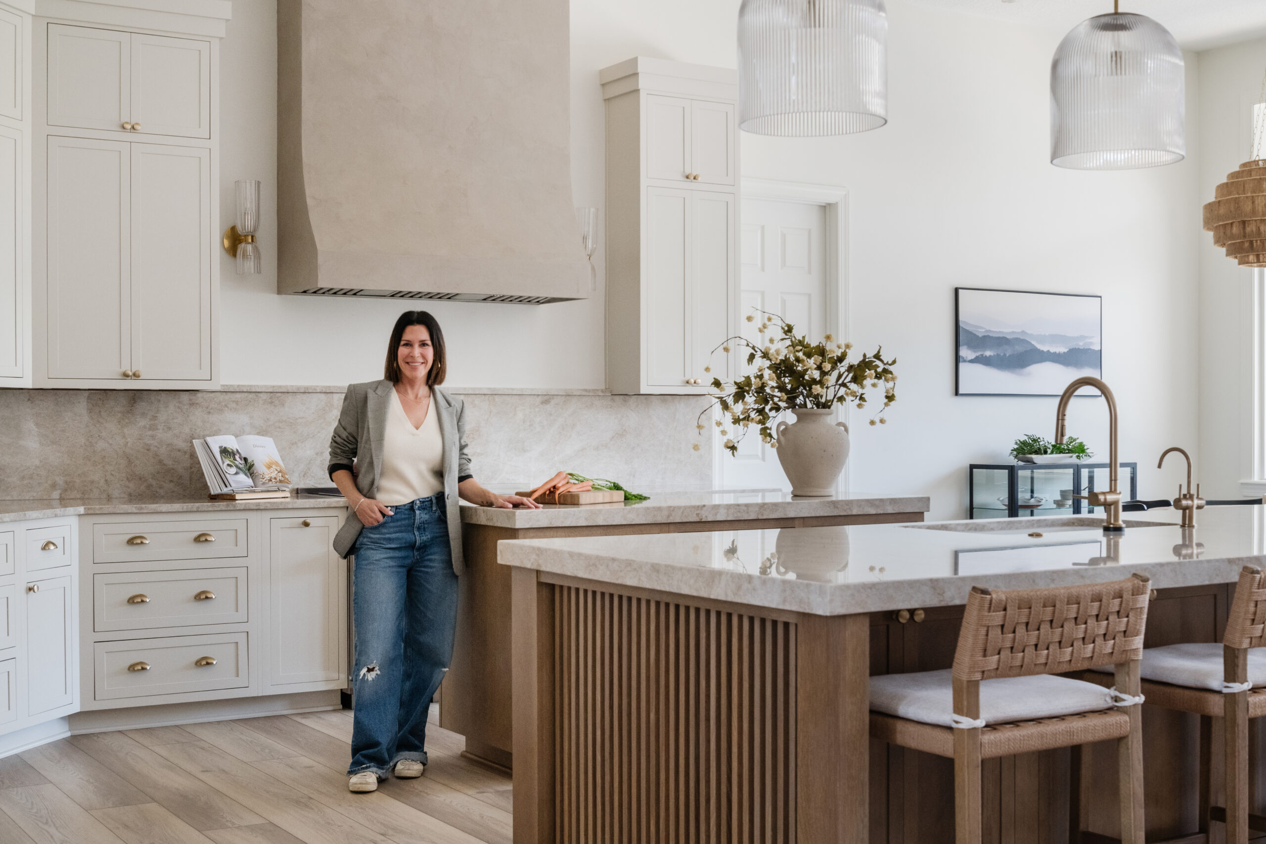 Florida interior designer, Jessica Woodward, is standing in a newly designed kitchen in a custom home.