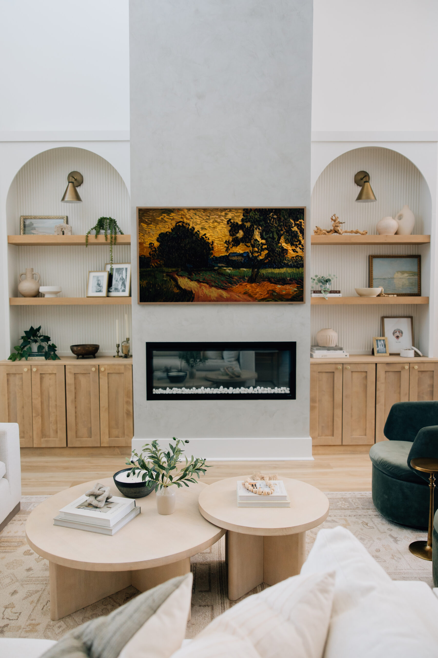 A modern living room fireplace accent wall features custom built-ins with floating shelves and a fluted wood panel backdrop.