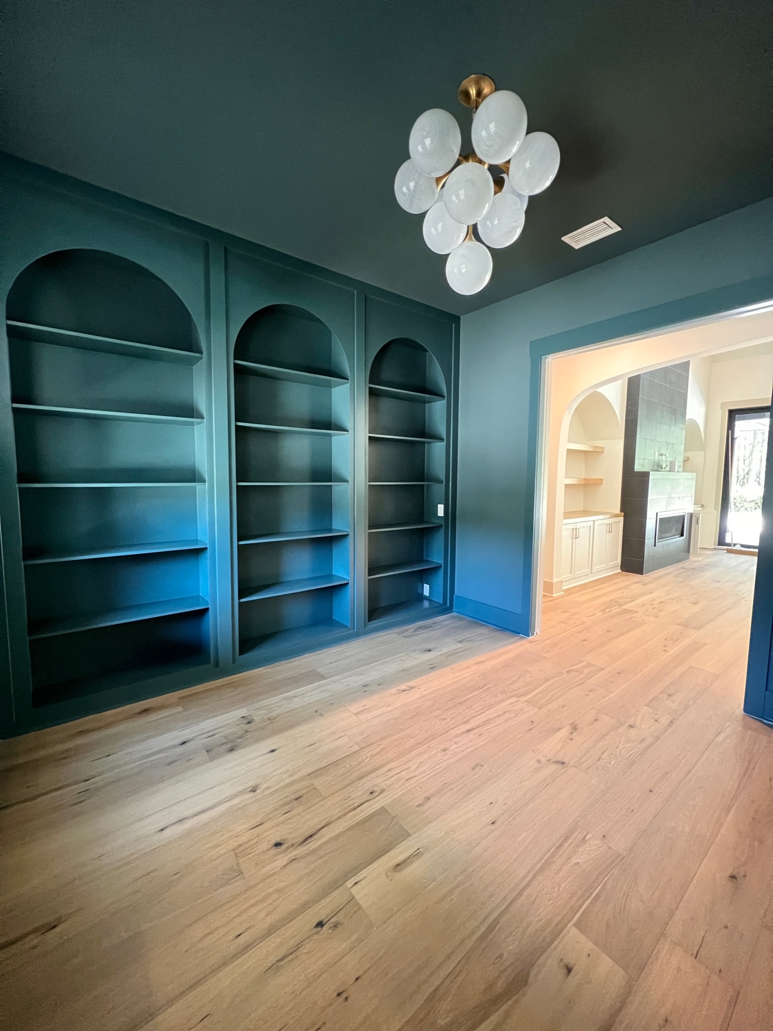 Room with built-in shelves painted entirely in relaxing bluish green.