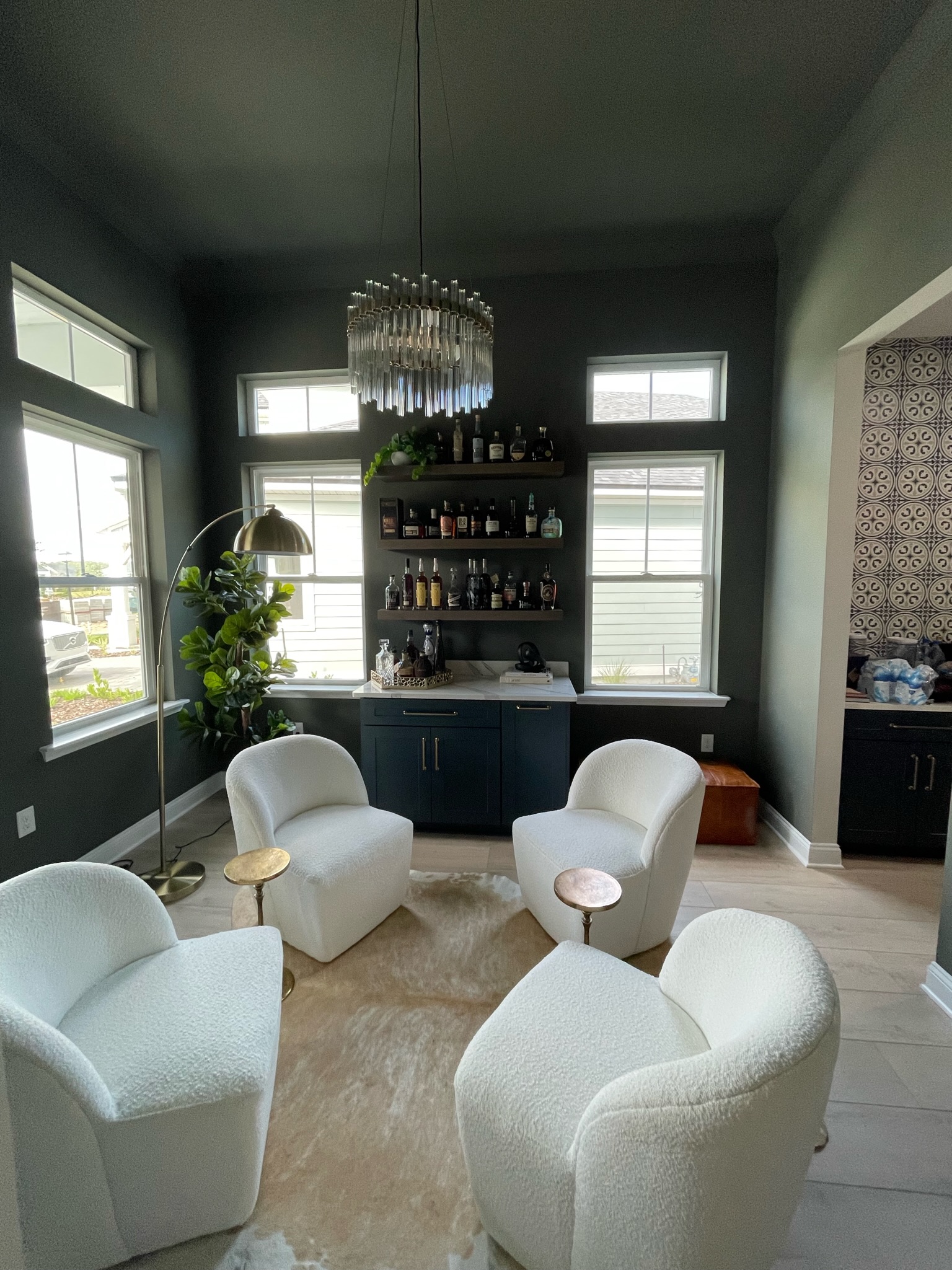 Conversation room with cozy white chairs and dark color-drenched interior